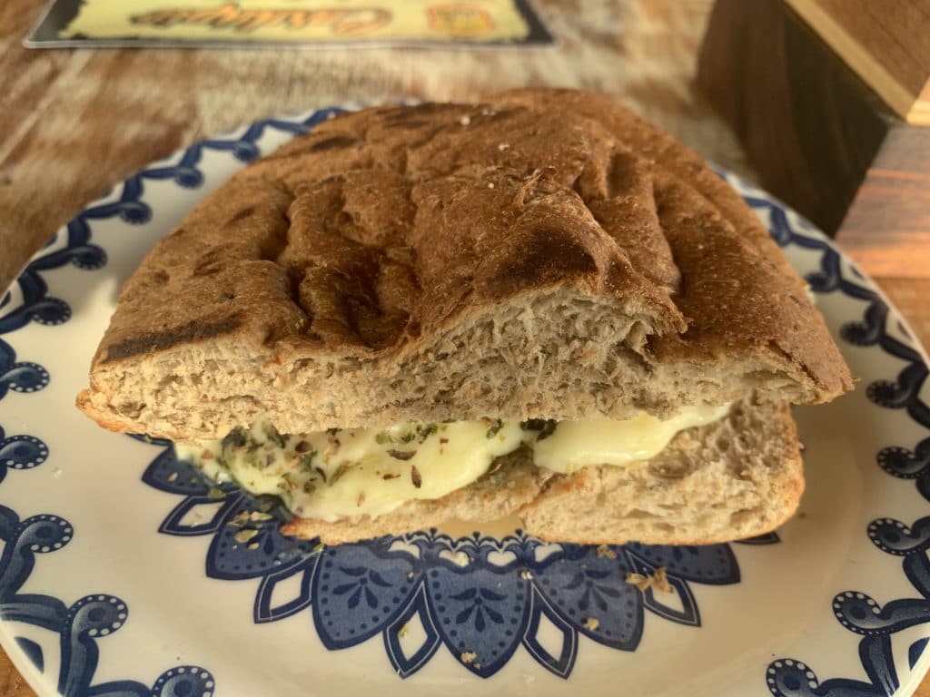 Barley bread sandwich with cheese, tomato, and oregano